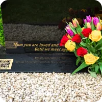 QR plaque on memorial with flowers